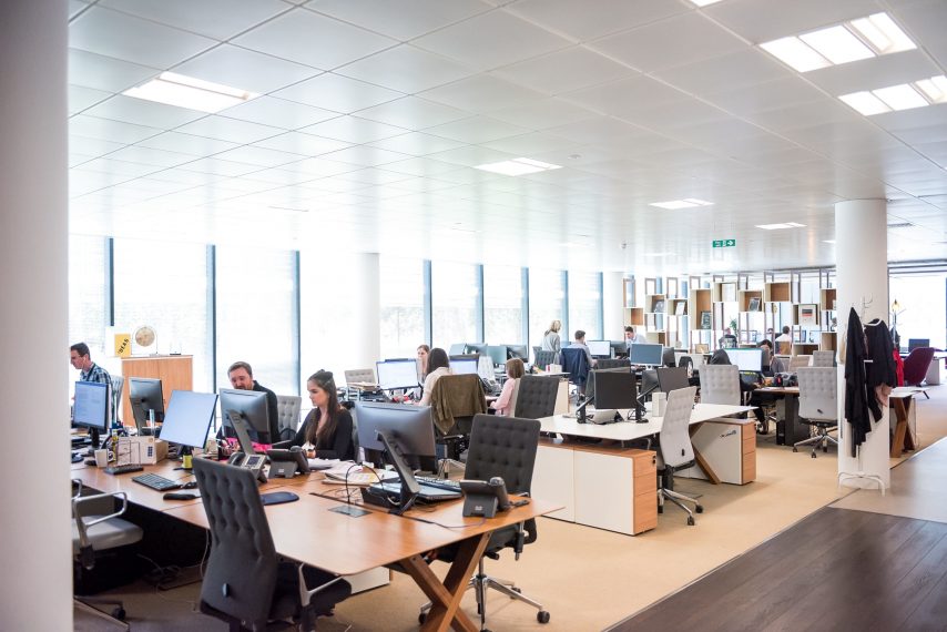 Photo of a customer service center, with rows of desks with agents working.