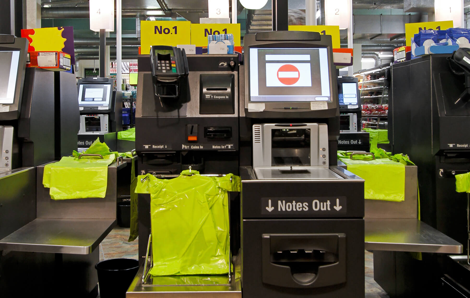 self check-out register with payment, grocery bags, and computer screen