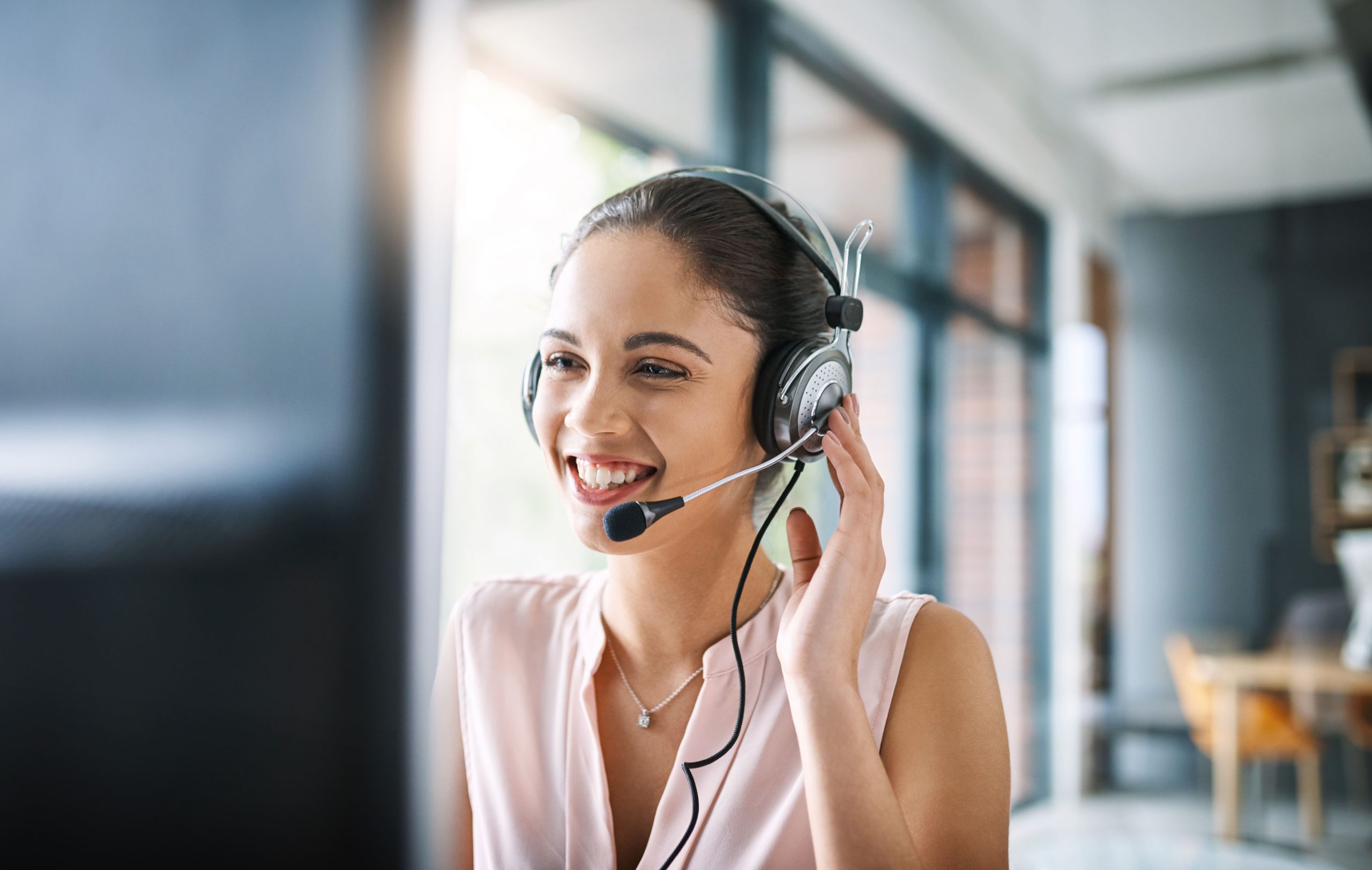 woman talking into a headset while sitting at a computer