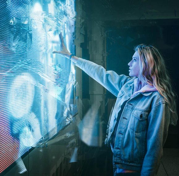 Woman looking and interacting by hand with a futuristic technology screen