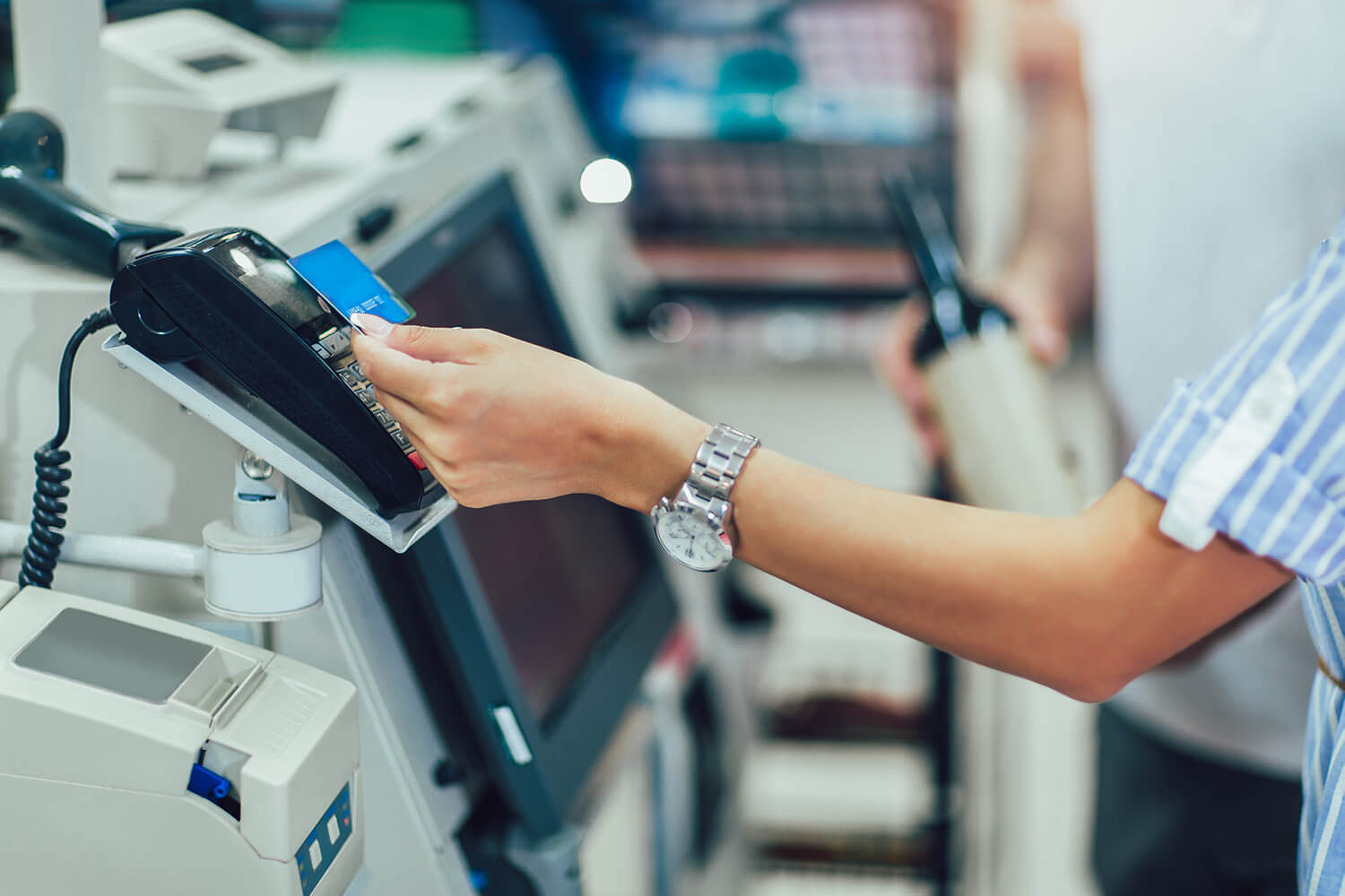 woman paying with credit card at a self check out stand