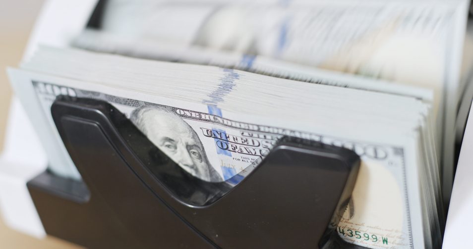 Photo of a stack of $100 bills in a register till