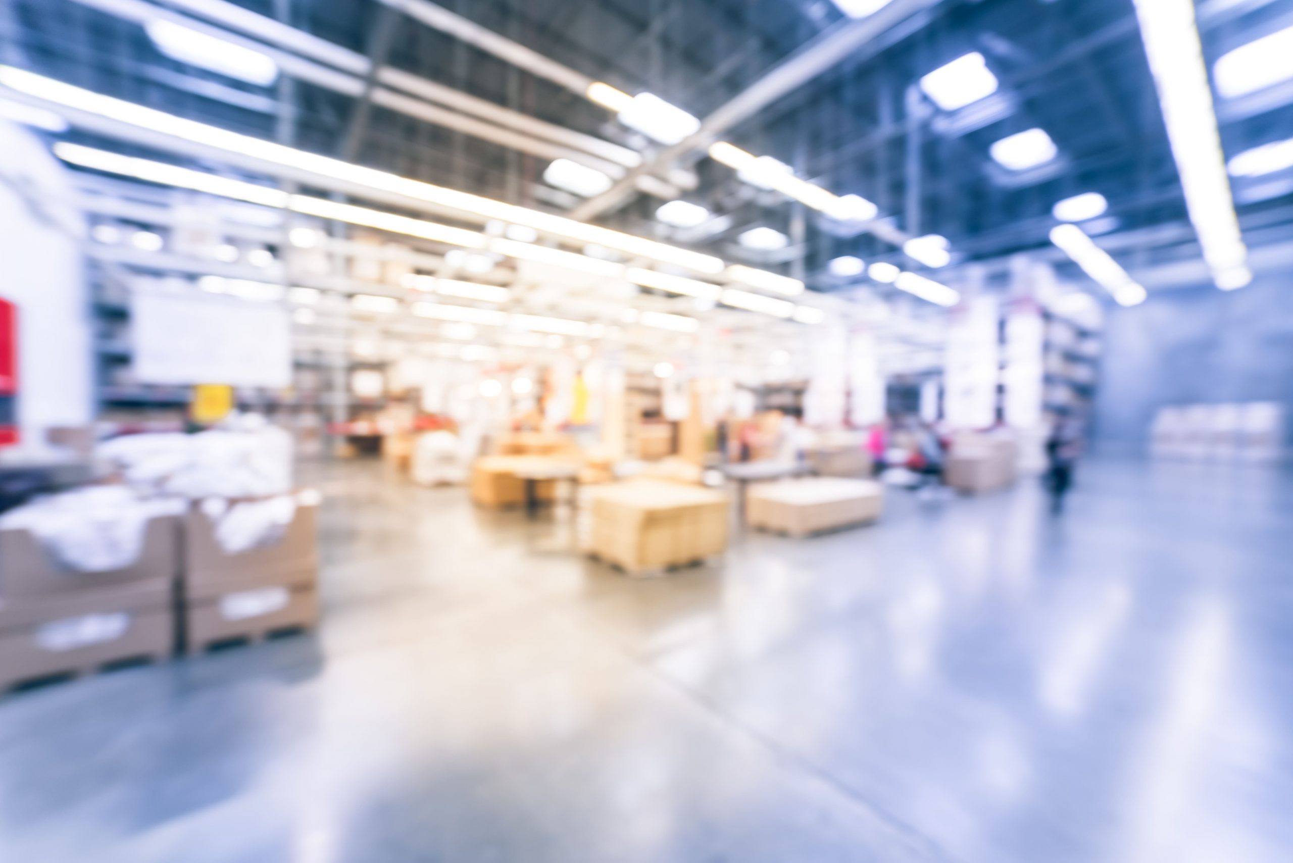 Blurred image of a large warehouse with rows of stacked products